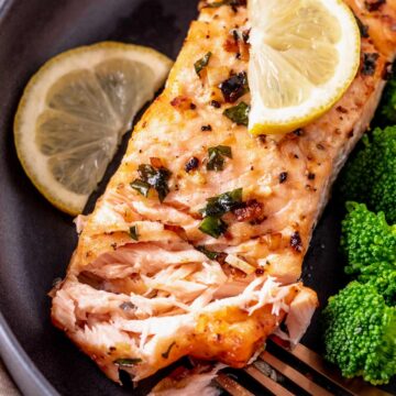 flaking salmon fillets with broccoli and lemon a plate