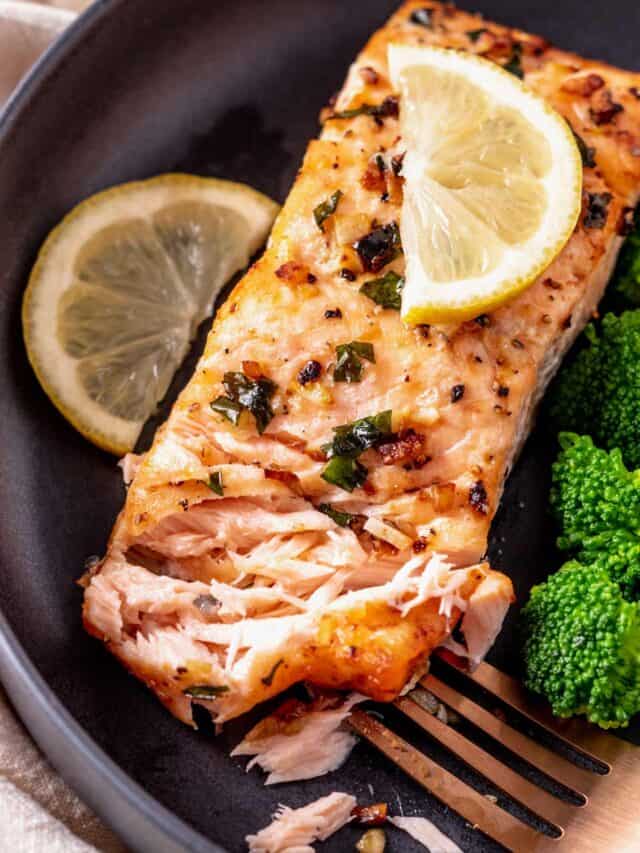 flaking salmon fillets with broccoli and lemon a plate