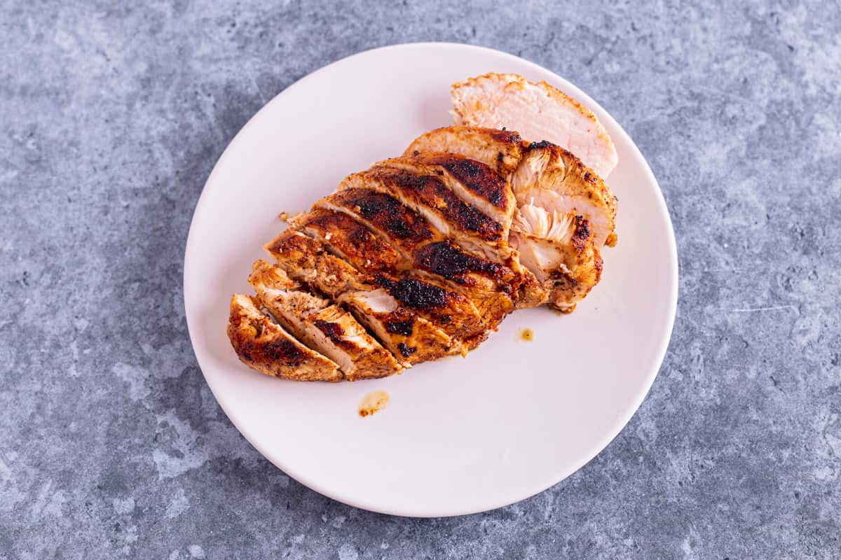 pan fried chicken breats sliced thin on a plate