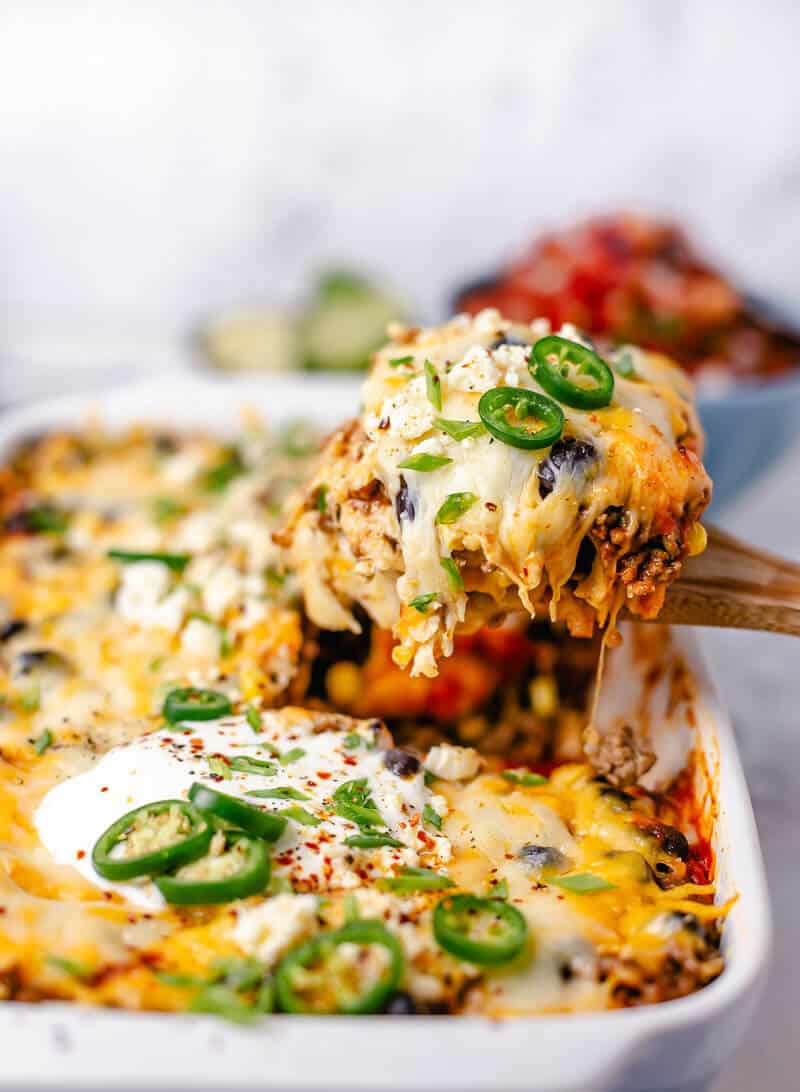Beef Enchilada Casserole close up on a wooden spoon