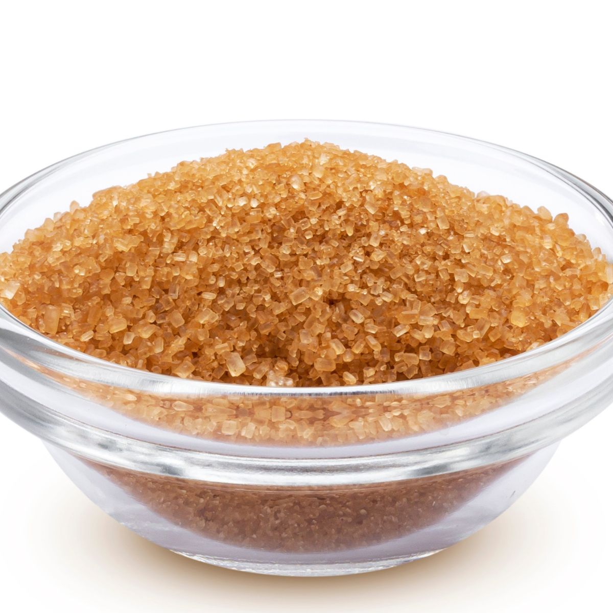 Glass bowl filled with coarse brown sugar crystals on a white background, illustrating brown sugar substitutes for baking.