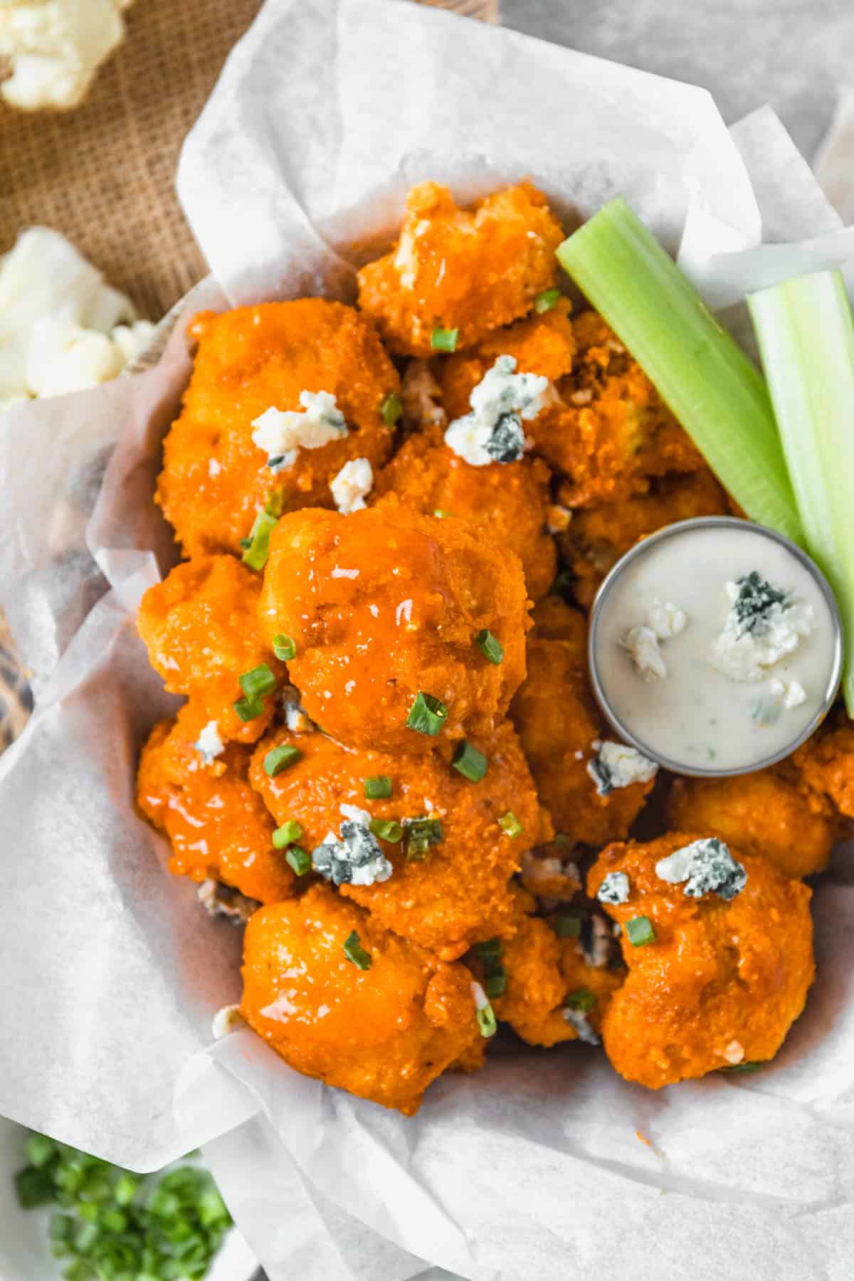 Buffalo Cauliflower Bites with blue cheese crumbles and sauce