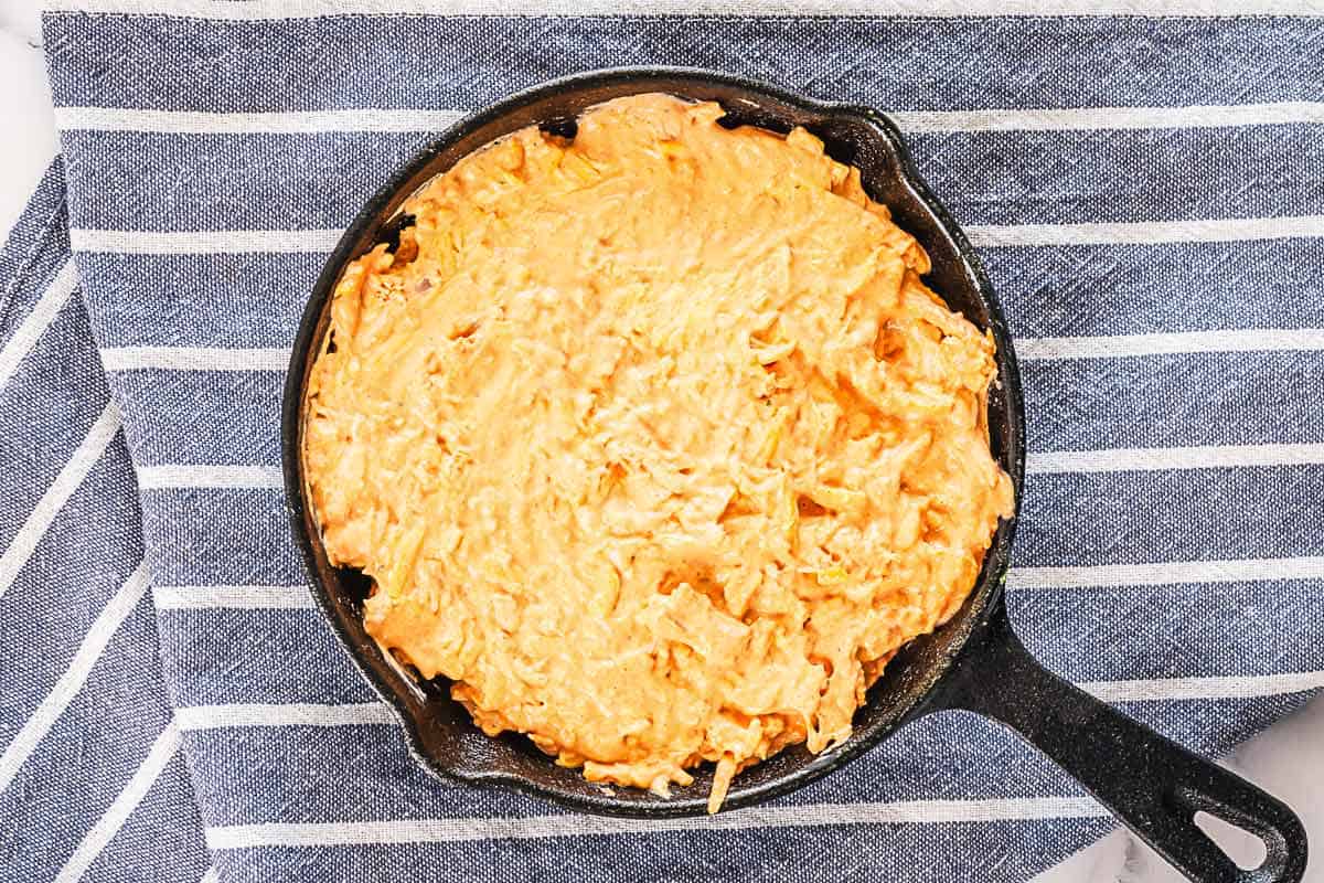buffalo chicken dip ingredients mixed in a cast iron skillet before baking