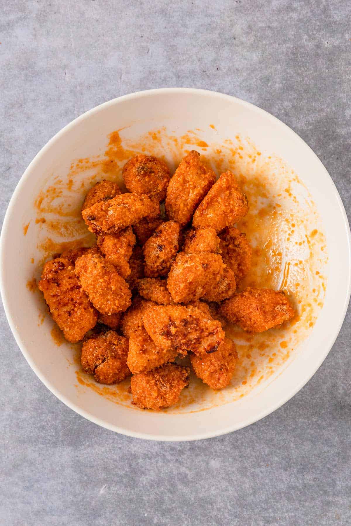 baked buffalo chicken pieces mixed in more hot sauce with butter