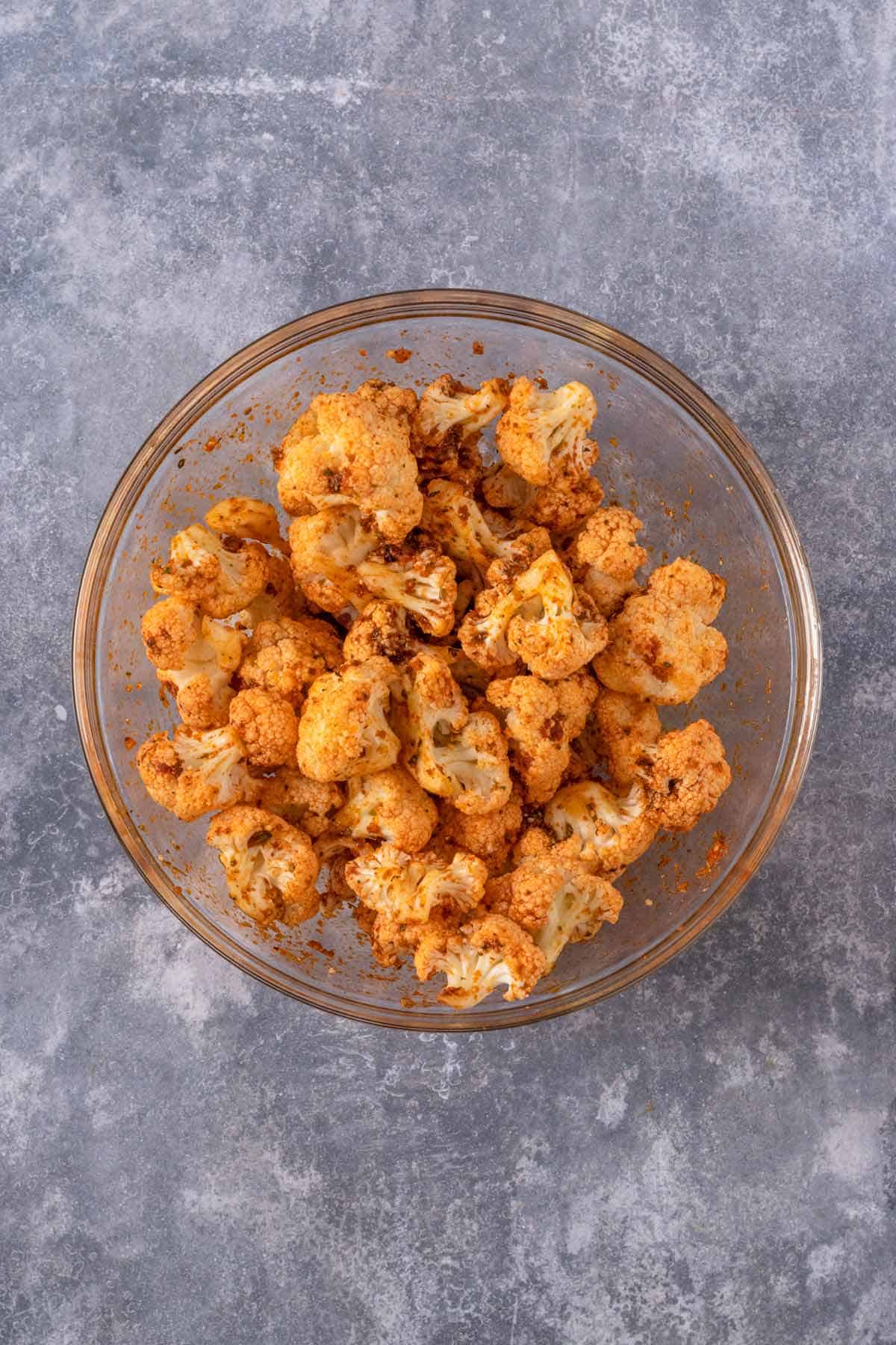 cauliflower bites in a bowl mixed with seasonings