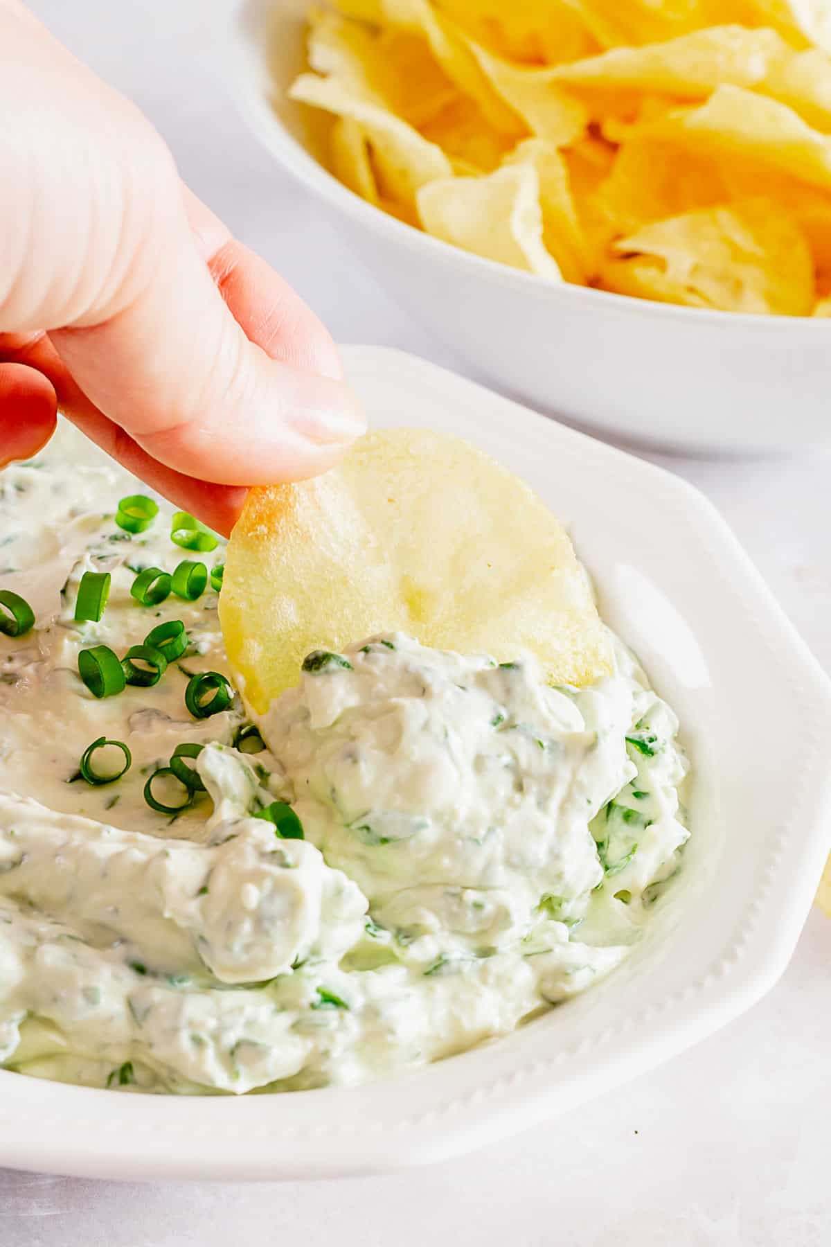 chips dunked into creamy cold spinach dip