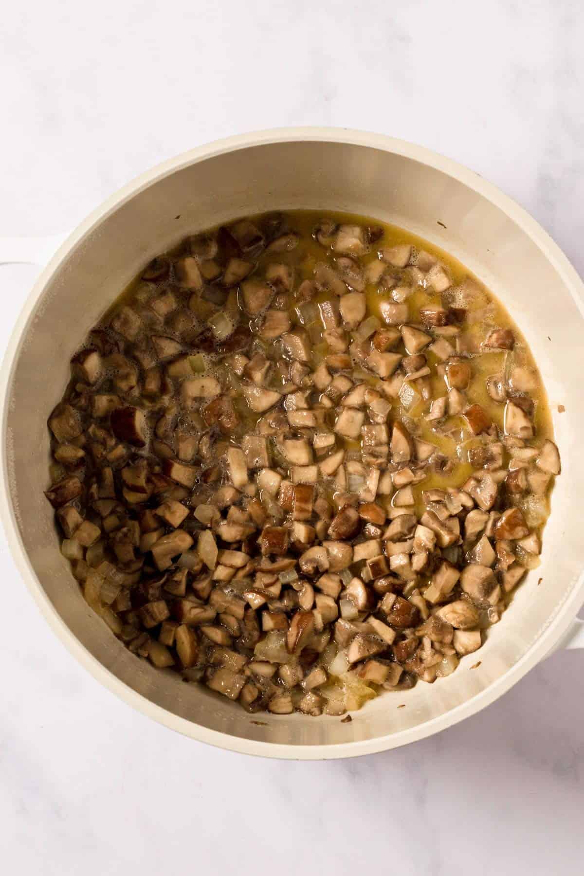 mushrooms and onion sauteeing in a pot