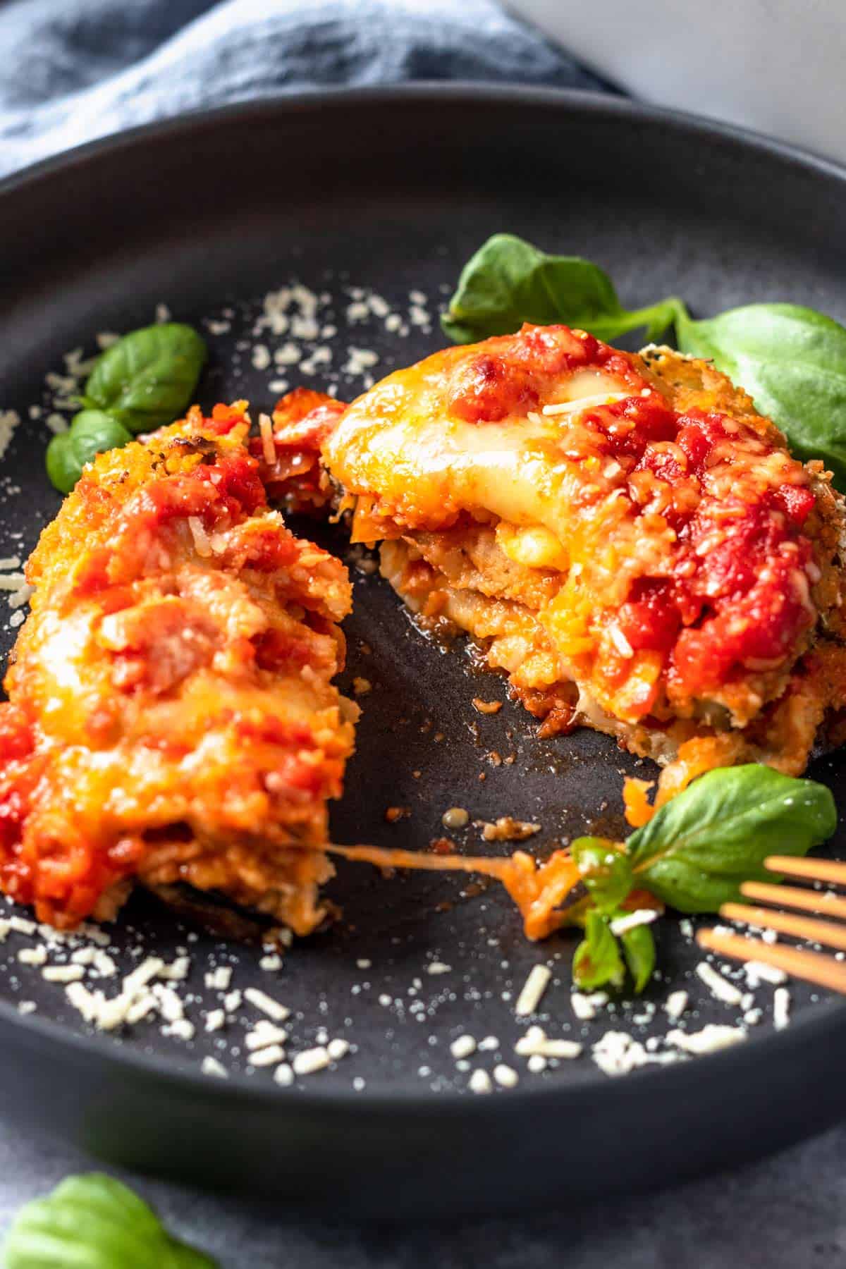 Gluten Free Eggplant Parmesan on a plate with basil leaves