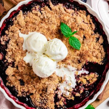 gluten free berry crumble after baking with three vanilla ice cream scoops on top