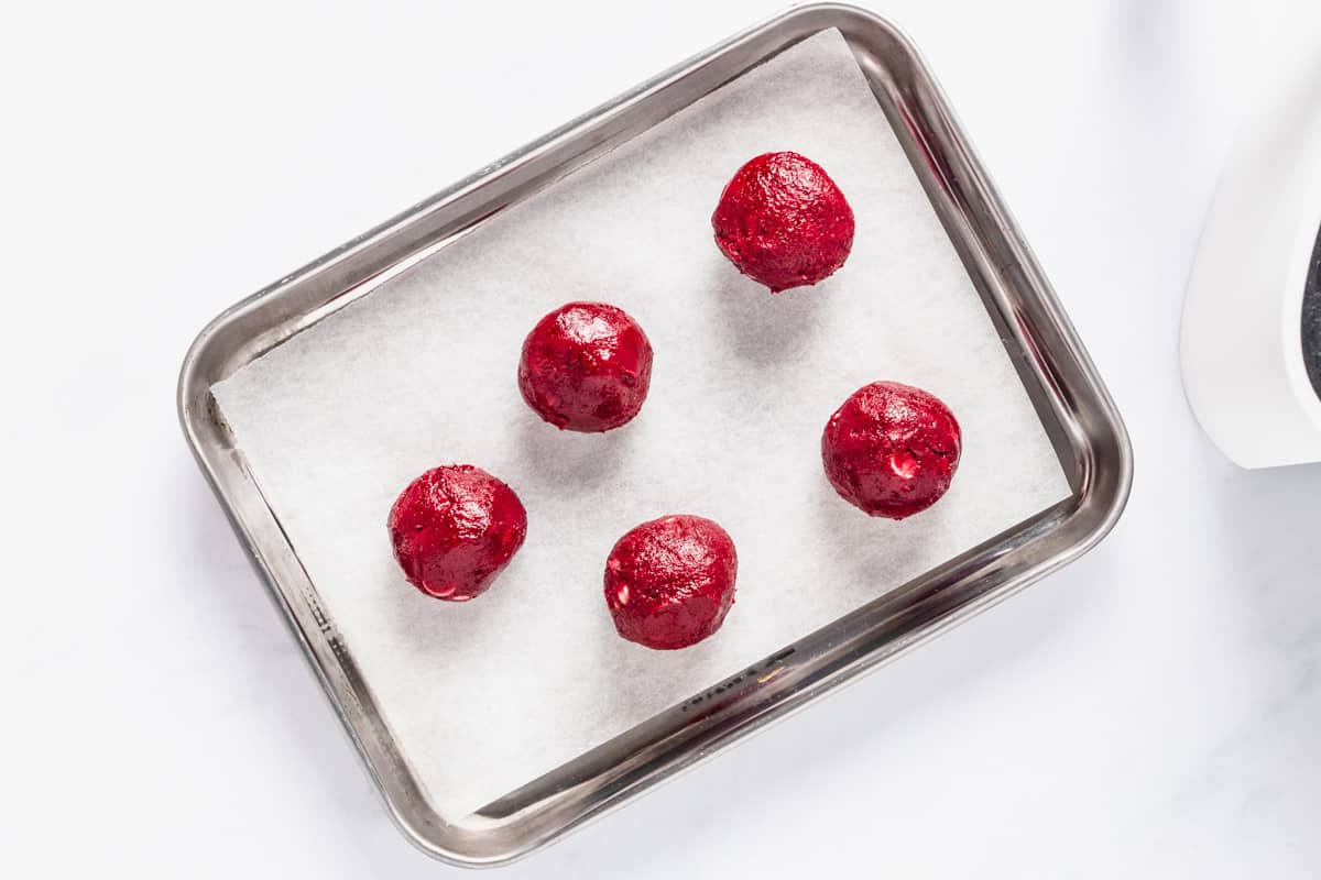 red velvet cookie dough balls on baking sheet