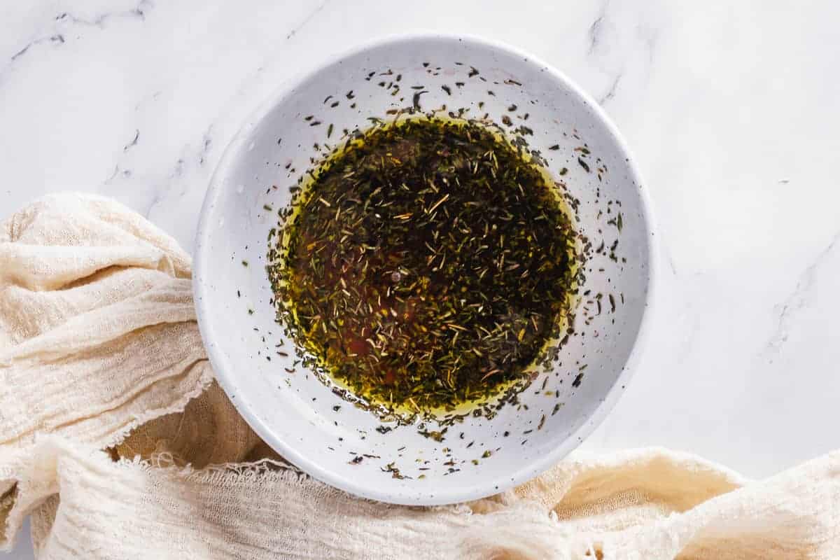 Vegetable marinade dressing in a white bowl on a marble background