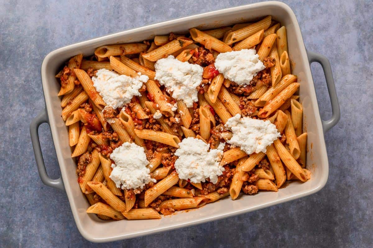 unbaked ziti topped with ricotta in casserole