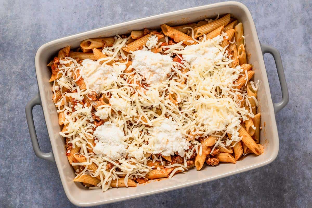 ziti ingredients in a bowl with ricotta and parmesan