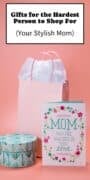 Pink gift bag with tissue paper, a decorative gift box, and a colorful Mother's Day greeting card displayed on a soft pink background.
