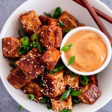 pan fried crispy tofu in a bowl with scallions