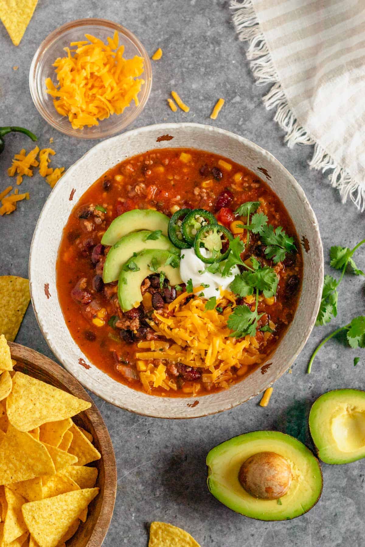 slow cooker taco soup with beef in bowl with toppings