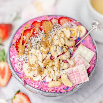 pink oatmeal porridge in a grey bowl with toppings