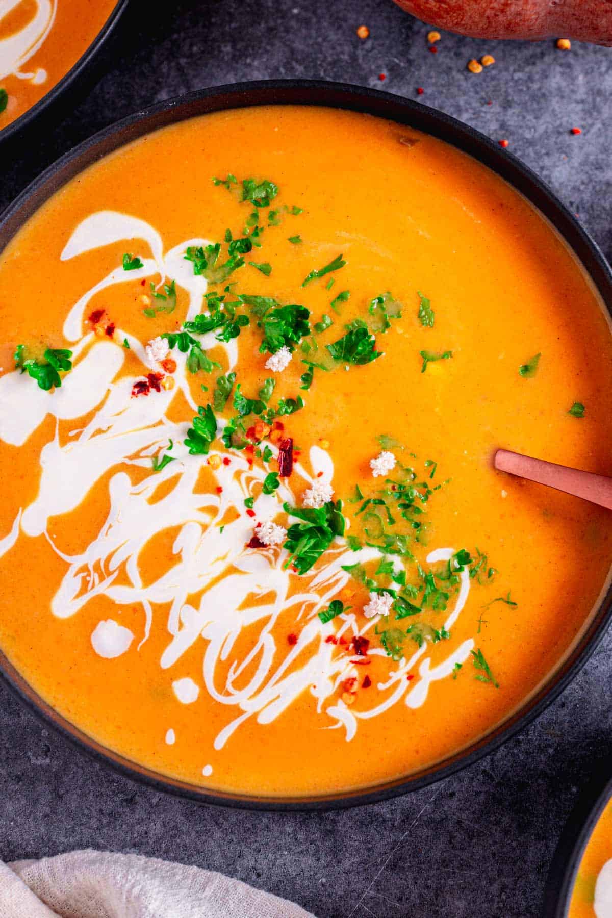 vegan pumpkin soup with cilantro and sour cream in a bowl