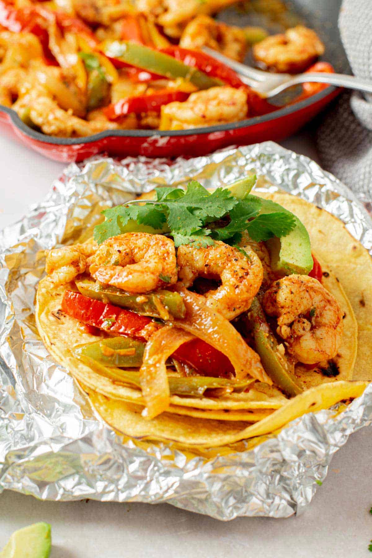 shrimp fajita with vegetables served in a corn tortilla ona foil