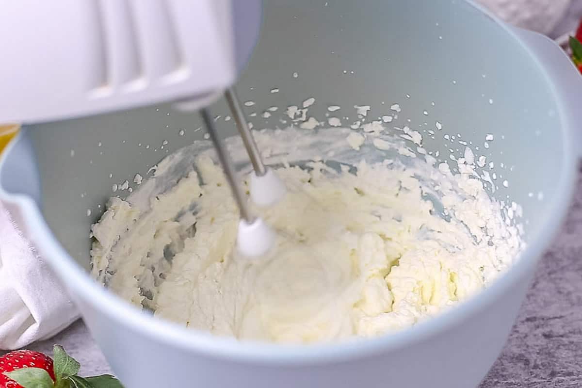 Whipped cream in a bowl with mixer handle
