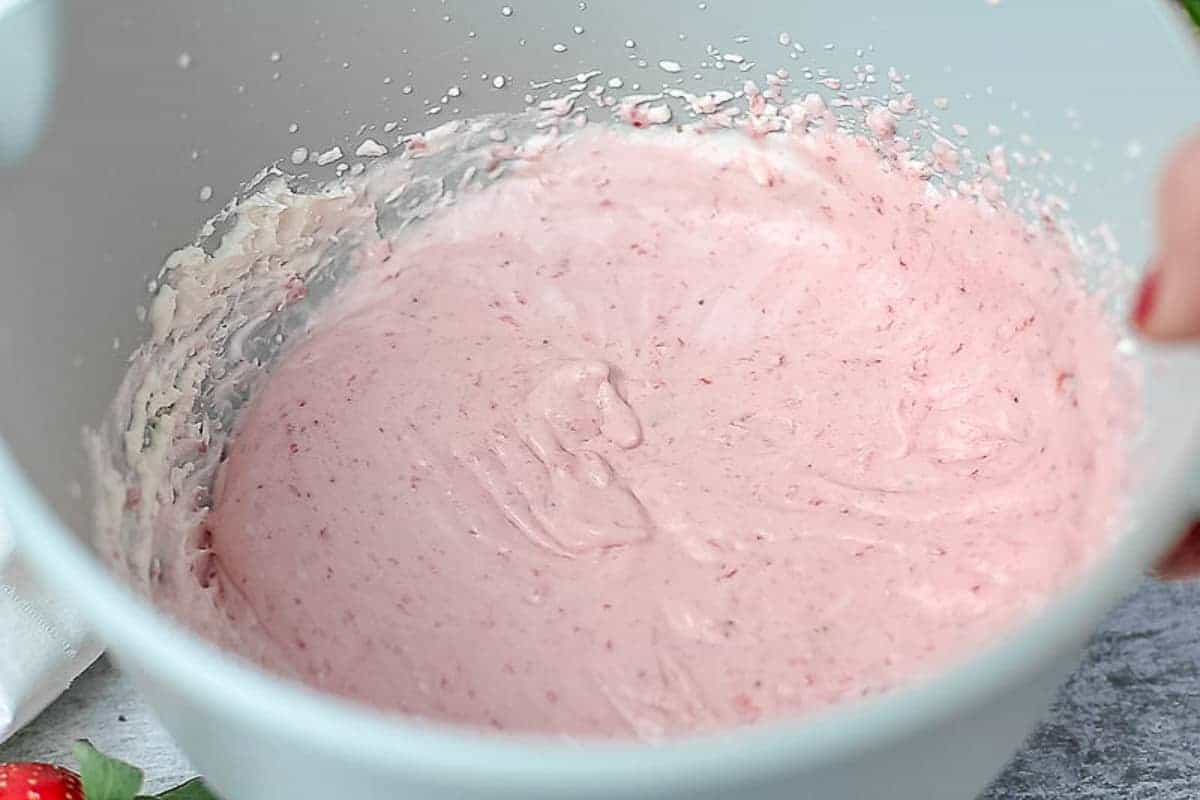 Strawberry puree whipped cream in a mixing bowl
