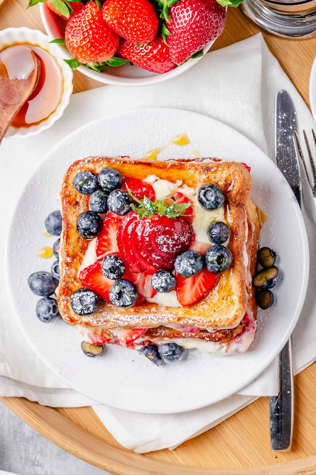 strawberry cream cheese stuffed french toast stacked on a plate