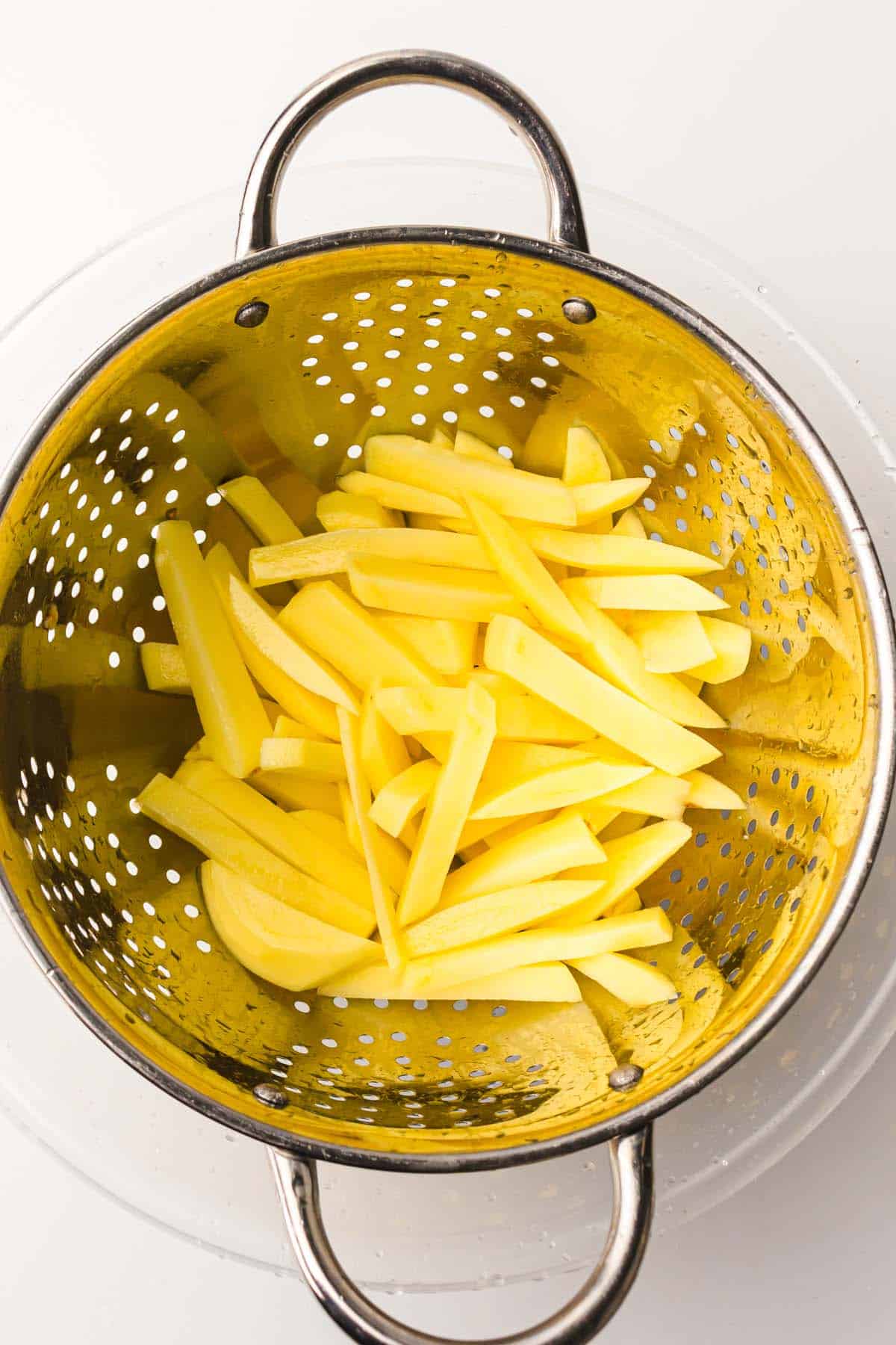 potato slices in colander.