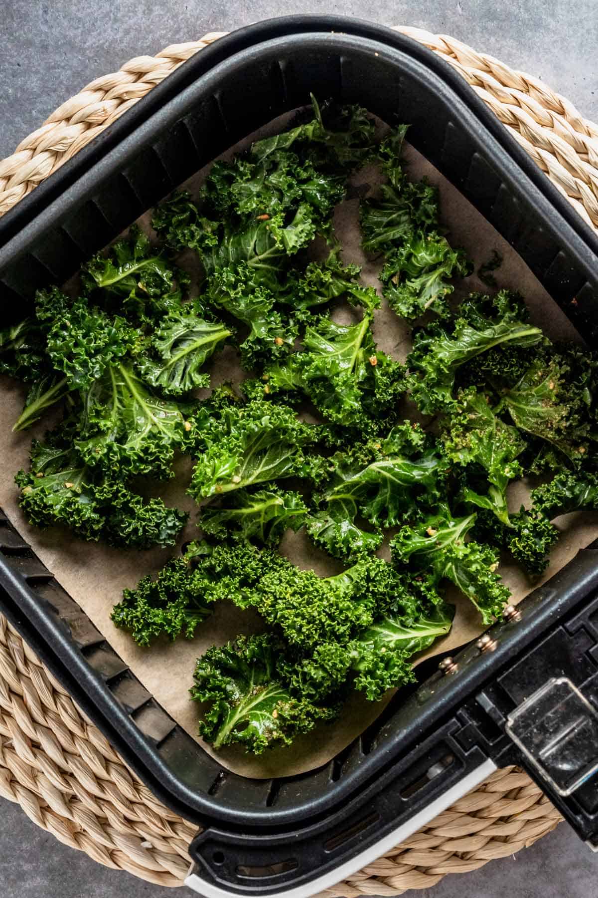 raw kale leaves in air fryer basket