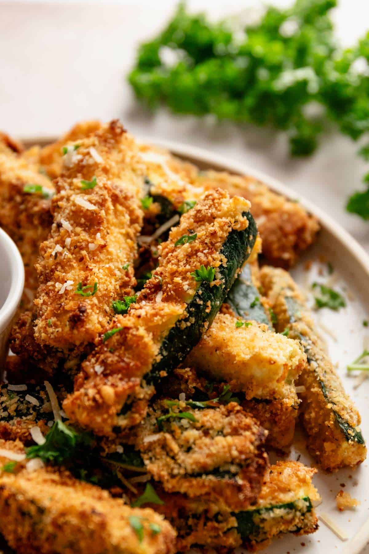 perfectly roasted golden brown zucchini fries on a bowl.