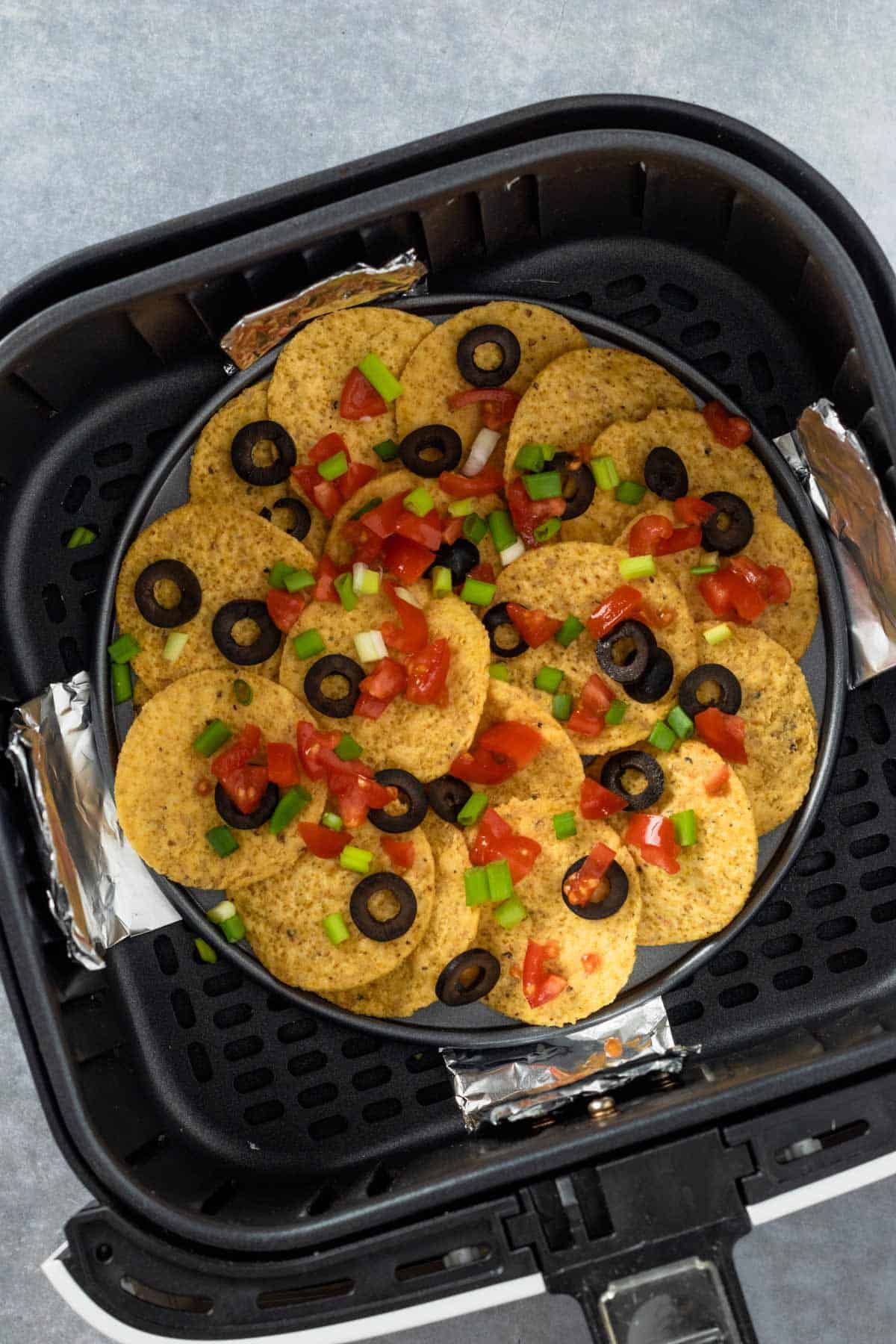nachos with toppings in air fryer basket