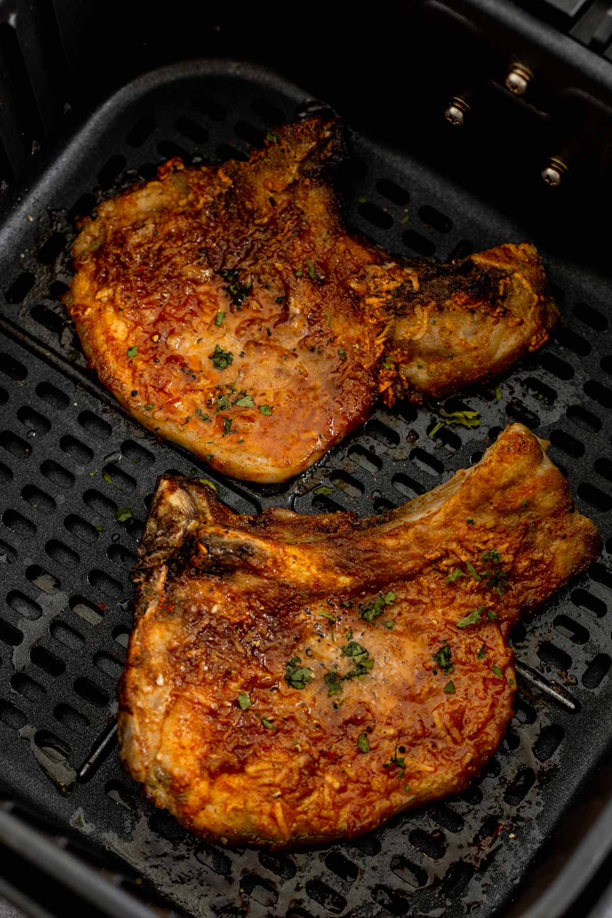 cooked bone in pork chops in a bowl with broccoli