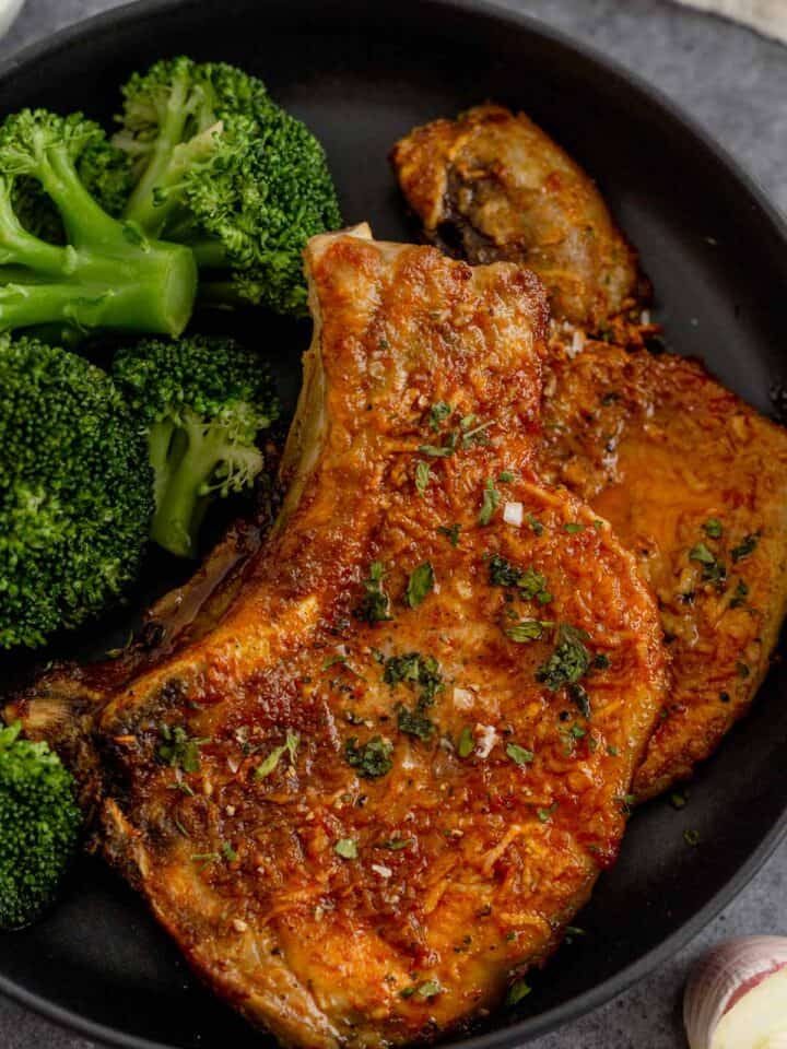 cooked bone in pork chops in a bowl with broccoli
