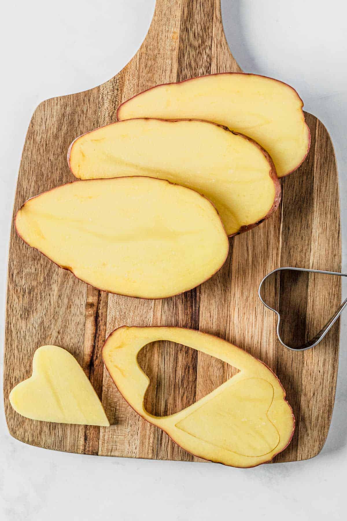 slicing the russet potatoes and cutting out heart shapes
