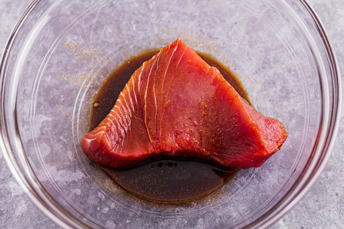 tuna steak marinating in a dark sauce