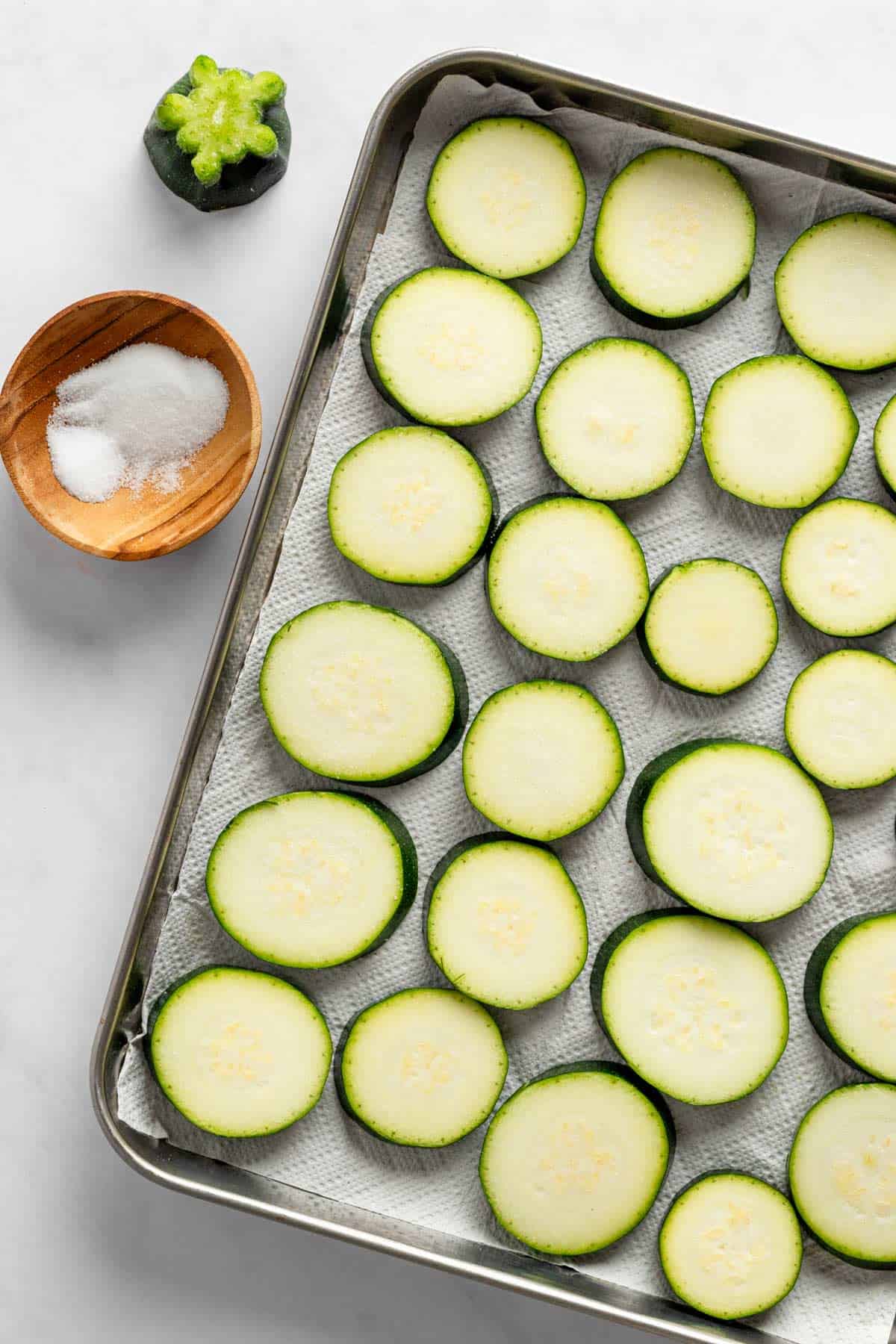 salted zucchini slices on baking sheet.