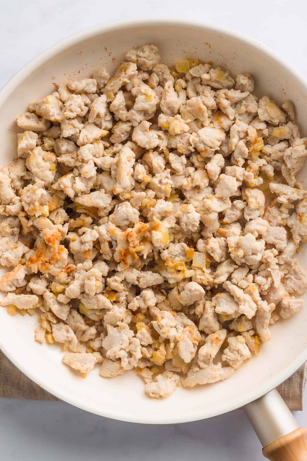 Cooked ground chicken spread on plate.