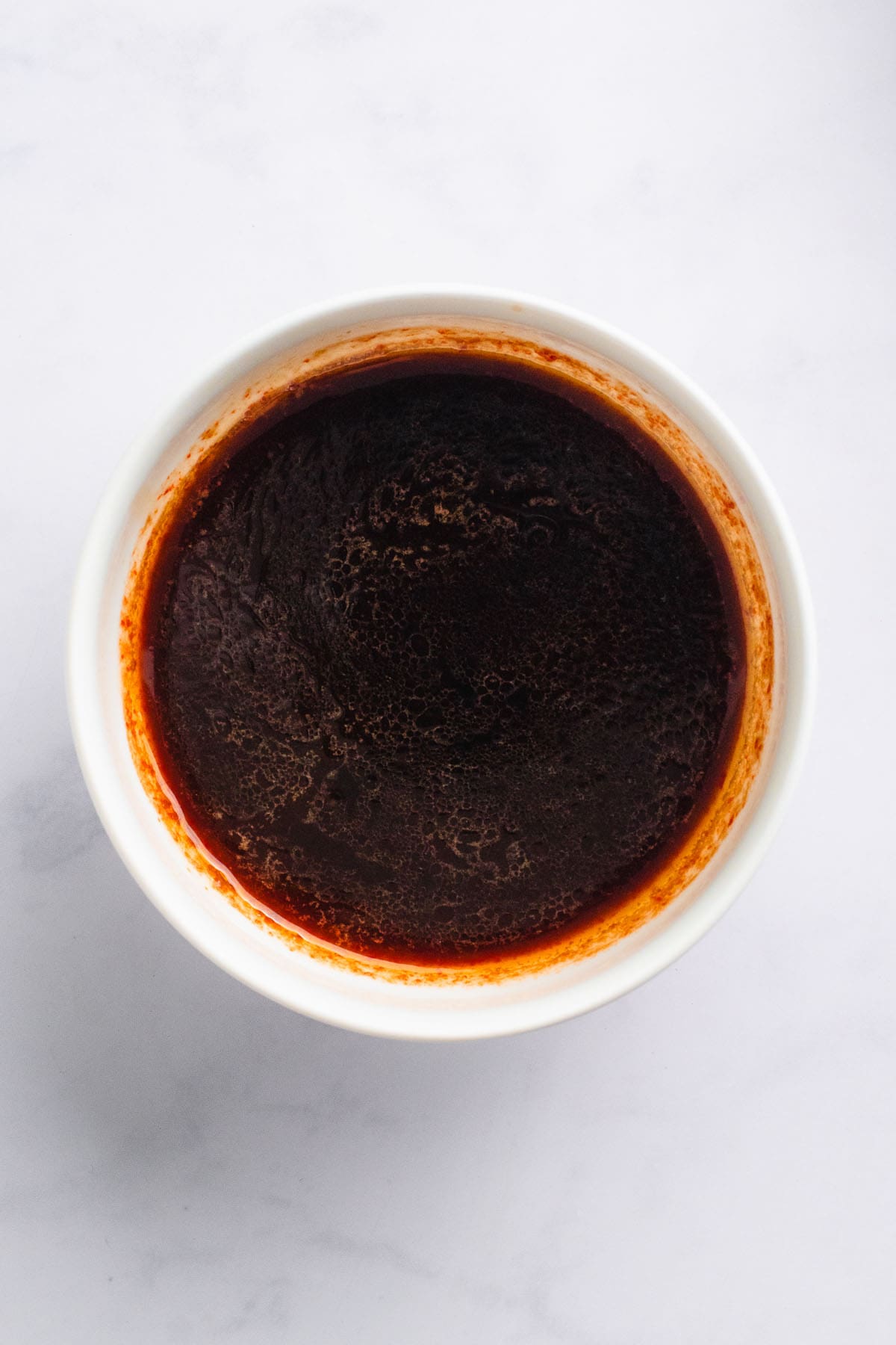 Small bowl of dark soy-based stir fry sauce.