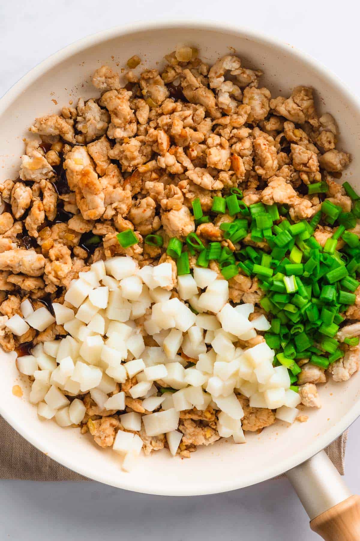 Ground chicken mixed with diced onions and chopped green onions.