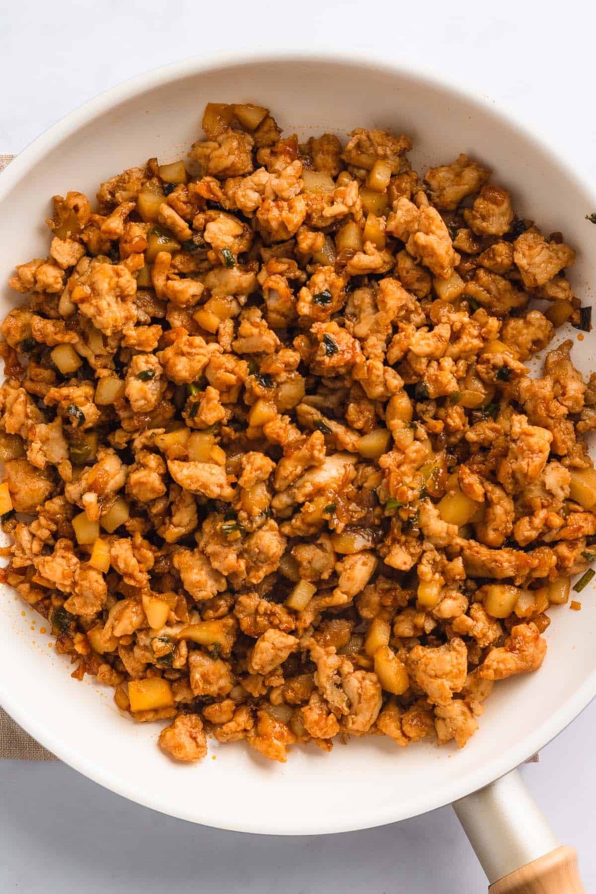 Cooked ground chicken browned in a skillet.