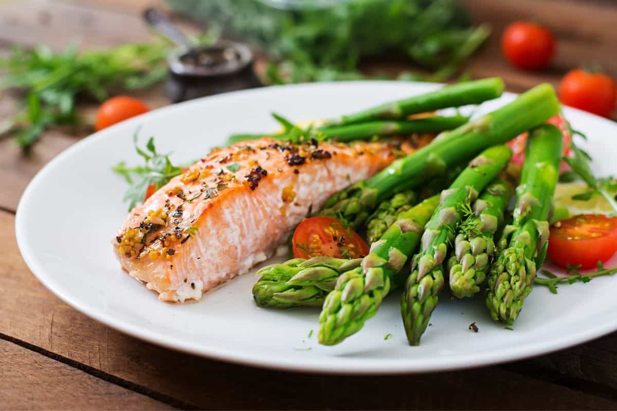 asparagus served with salmon fillet on a plate.