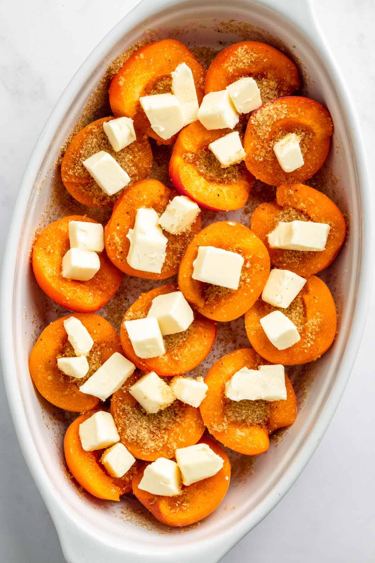 Apricots in baking dish with butter.