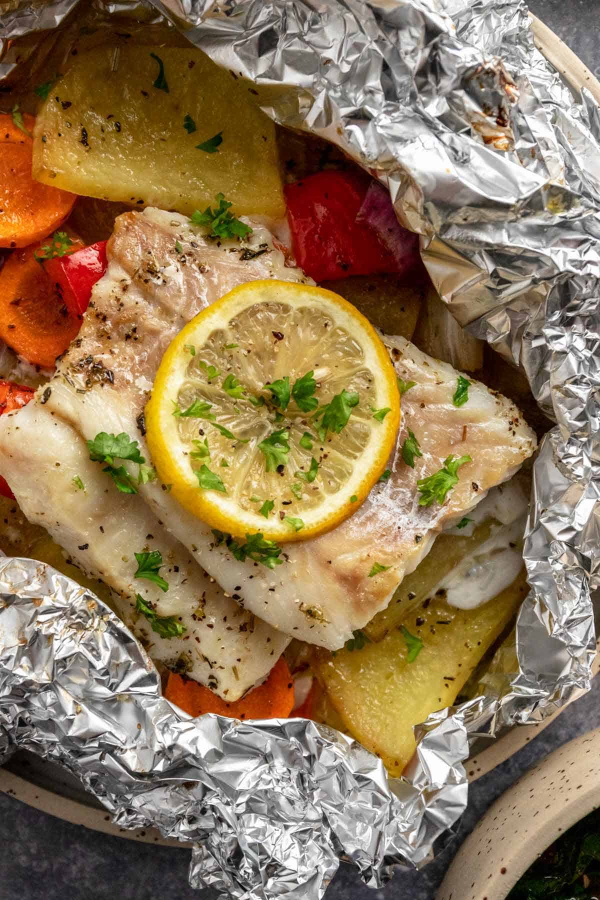 baked cod fillets in foil with vegetables and lemon