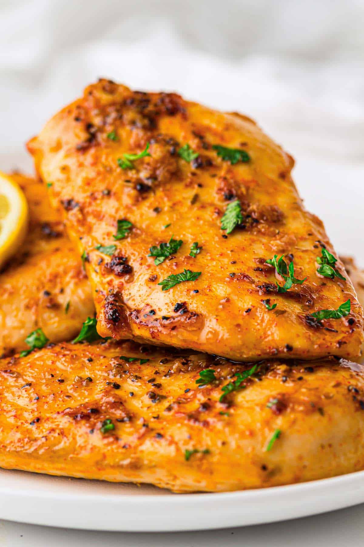 Juicy oven baked lemon garlic chicken breast with parsley garnish.