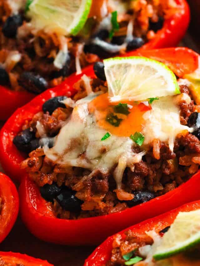 Close-up of baked stuffed bell pepper topped with cheese and lime.