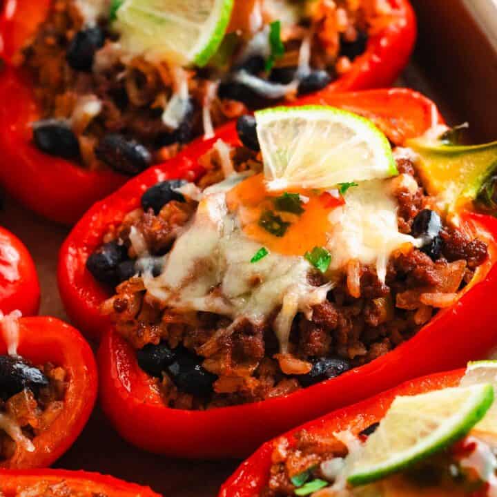 Close-up of baked stuffed bell pepper topped with cheese and lime.
