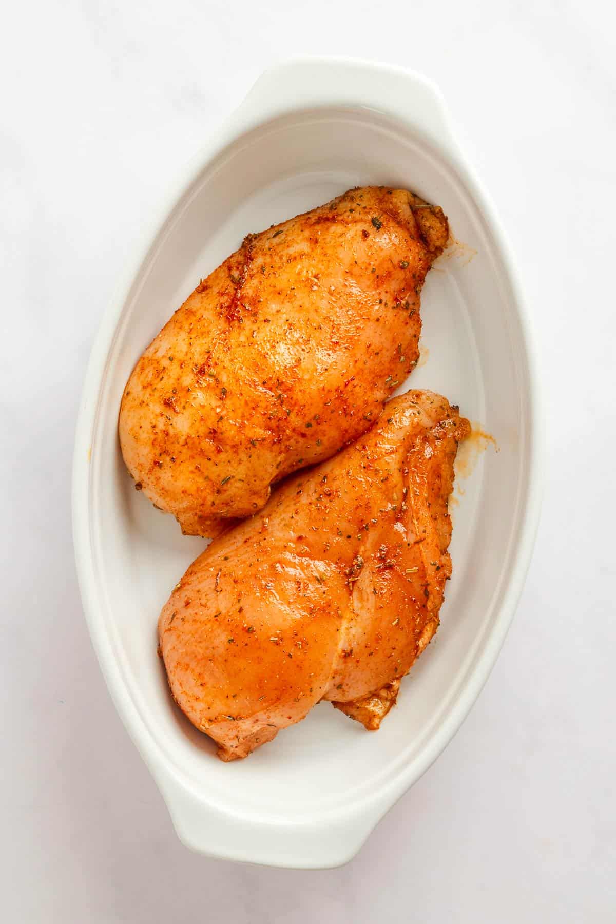 marinated chicken breast in baking dish.