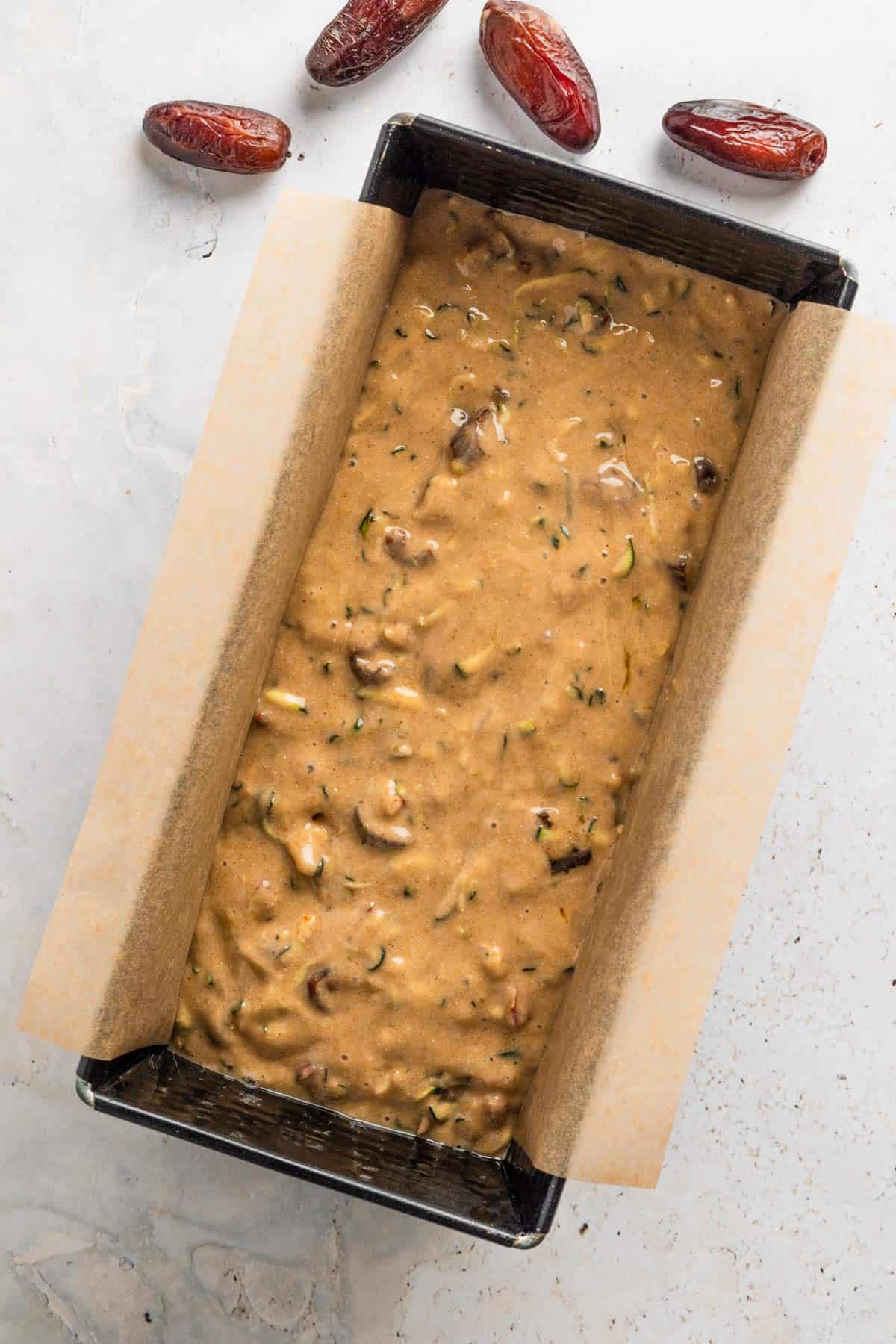 Zucchini nut bread batter in a loaf pan.