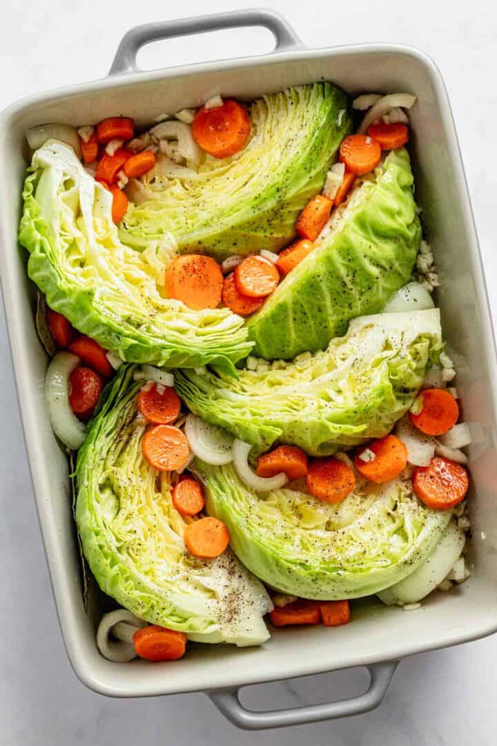 cabbage wedges and carrots in casserole dish.