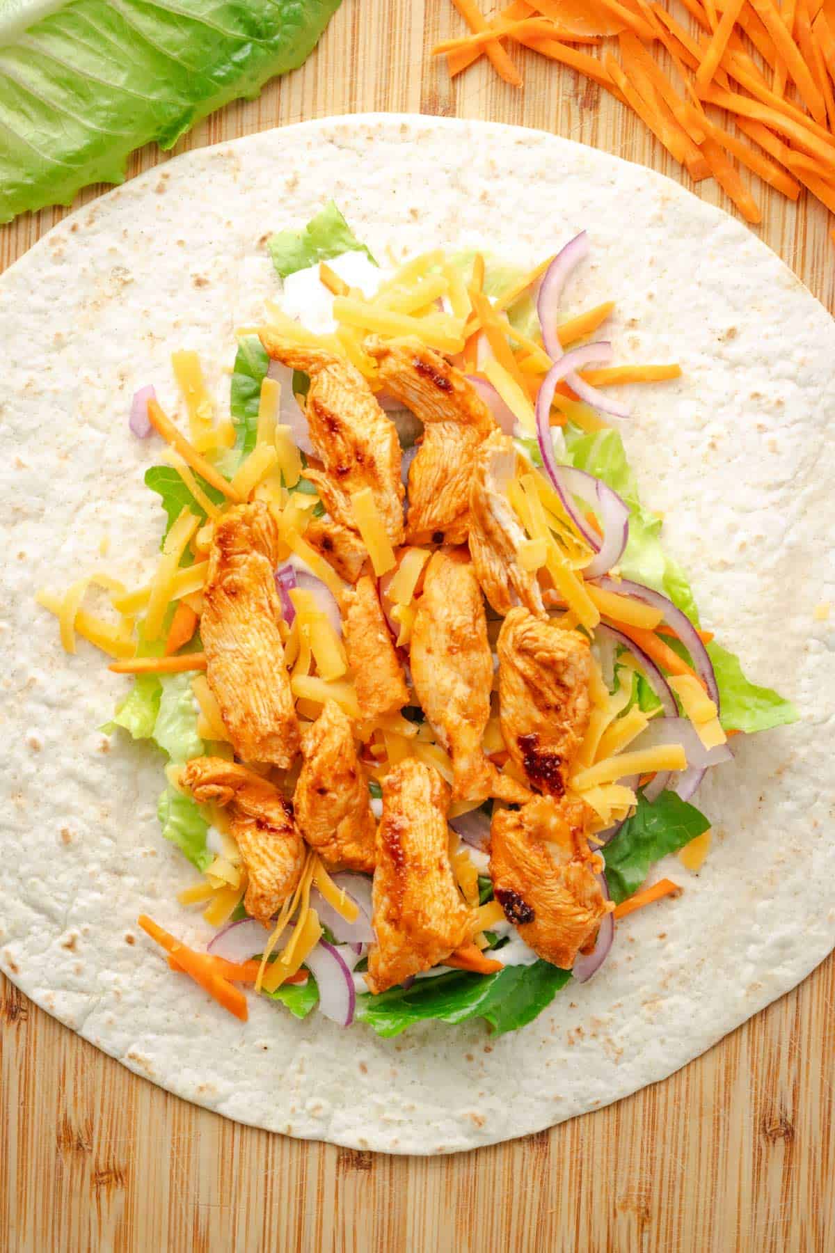 Adding the filling to buffalo chicken wrap.