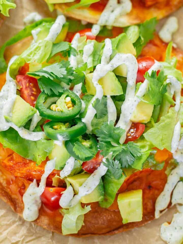 crispy tostadas with buffalo chicken toppings and ranch dressing close up shot